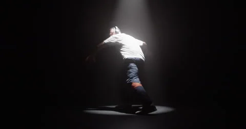 Active talented man dancing breakdance in dark studio Stock Footage 244524431