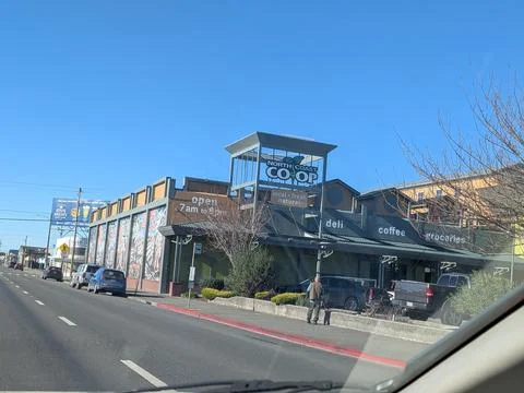 Active three-lane roadway lined with traffic beside North Coast Co-op Stock Photos