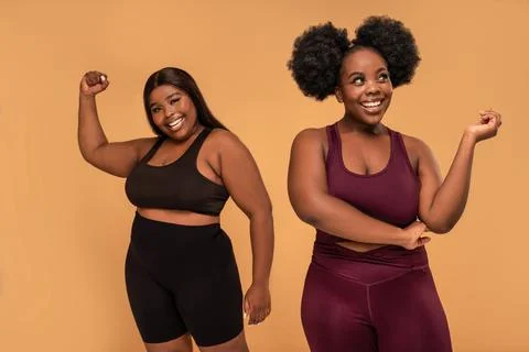 Active two plus size women after training in fashionable sporty clothes posin 스톡 사진