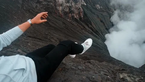 Active volcano Bromo on the island of Java in Indonesia with a guy sitting on Stock Footage 130592893