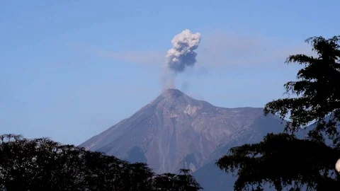Active volcano emits small puff of white and grey smoke on a clear day. Vídeos de archivo 100365783