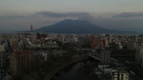 Active Volcano Looming Large over Japanese City at Dusk 動画素材 210029345