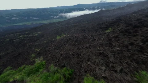 Active volcano solidified lava fpv drone through the clouds Stock Footage 275339756