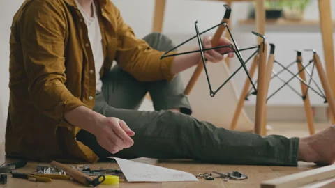 Active white guy Intensely Assembles quickly prefabricated furniture with hi Stock Footage 242450965