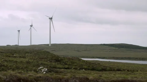 An active wind farm by a loch on a Hebridean moor Stock Footage 332135191
