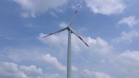 Active wind mill with a cloudy but blue sky in the background Stock Footage 92874445
