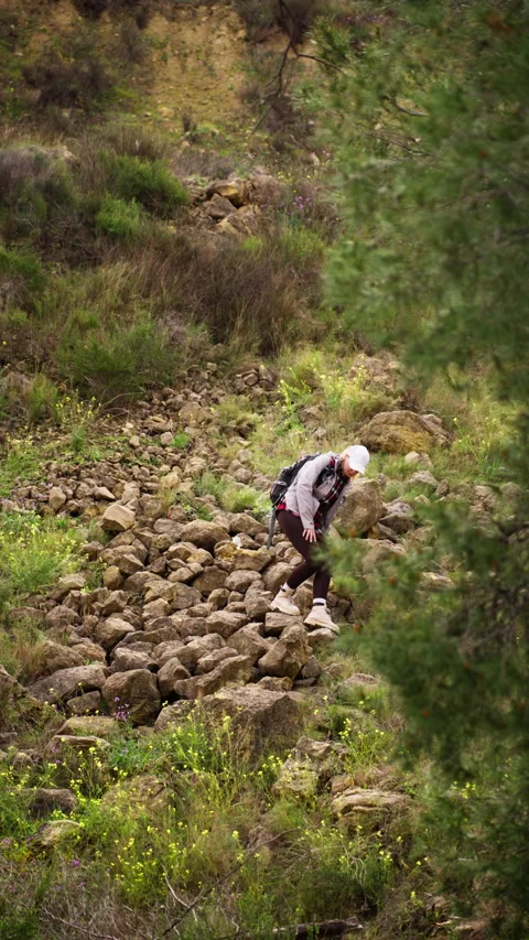 Active woman with backpack hiking down difficult, rocky path in mountain fo.. Stock Footage 334666563