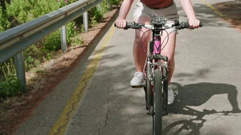 Active woman bikes on forest path. Female cyclist pedals fast through rich woods Stock Footage 280867912