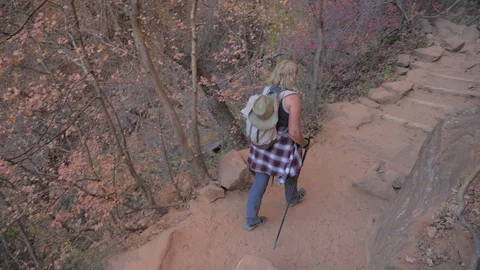 Active Woman Hiking Down A Steep Trail Over Huge Rocks In Mountains Zion Park Stock Footage 86547362