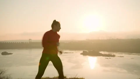 Active woman practicing fighting exercises at sunset Stock Footage 153726658