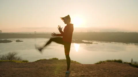 Active woman practicing fighting exercises at sunset Stock Footage 153726943