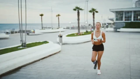 Active woman with prosthesis looking at smartwatch during run training outdoors Stock Footage 137794392