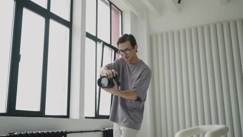Active work of photographer in photo studio with large windows. Concept of photo Video stock 243458183