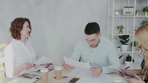 Active workflow in the design studio. Colleagues review and study illustrations Stock Footage 106193066