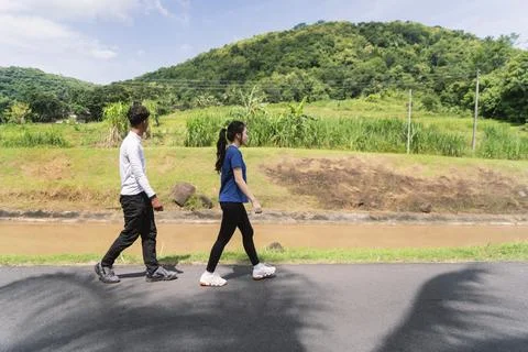 Active young asian couple walking exercise at rural area Fotos de archivo