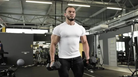 Active young bodybuilder lifting heavy weights black dumbbells for biceps. Stock Footage 167824217