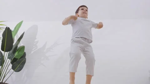 Active young boy jumping on the bed Stock Footage 245961400