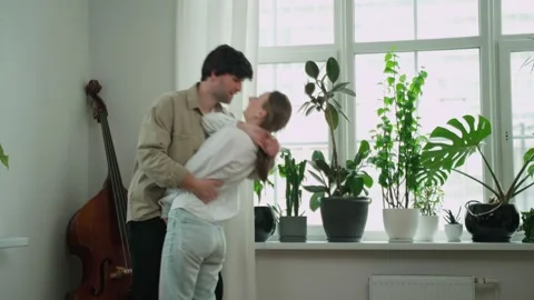 An active young couple dancing and having fun in the living room of the house, a Stock-Footage 239673179