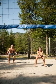 Active young couple play beach volley  on hot wimmer day Stock Photos