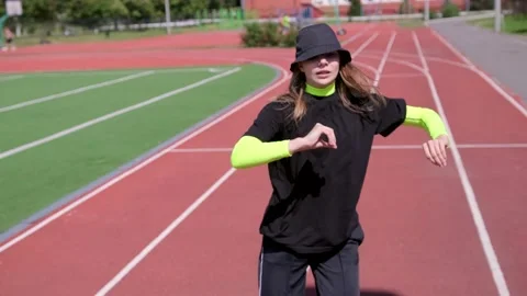 Active young girl dancing hip hop and break dance on the stadium treadmill Stock Footage 138992891