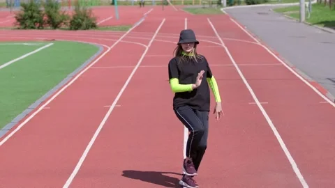 Active young girl dancing hip hop and break dance on the stadium treadmill Stock Footage 138993034
