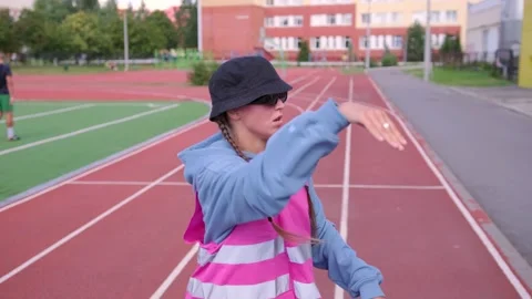 Active young girl dancing hip hop and break dance on the stadium treadmill Stock Footage 139458401