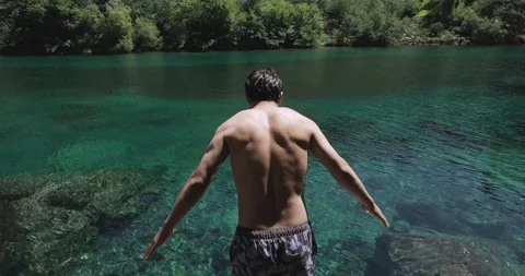 Active young man dives into breathtaking crystal clear turquoise mountain lake. Stock Footage 248189380
