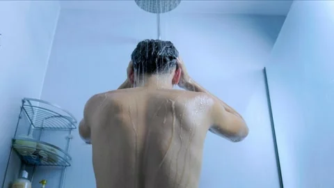 Active young man washing his hair under the shower in the home bathroom. Stock Footage 345530990