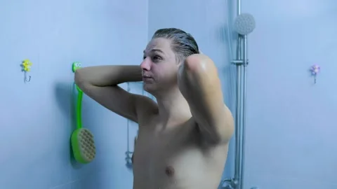 Active young man washing his hair under the shower in the home bathroom. Stock Footage 345531044