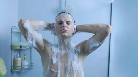 Active young man washing his head with thick shampoo foam in the home shower. Stock Footage 345531223
