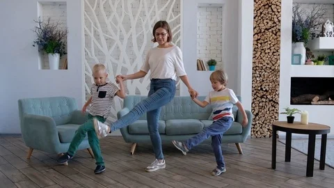 Active young mom and cute boys dancing in modern house living room Stock Footage 116656462