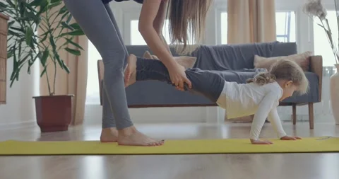 Active young mom and cute little kid daughter play on mat at living room, happy Video stock 148220568