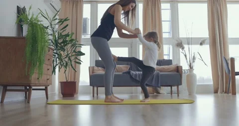 Active young mom and cute little kid daughter play on mat at living room, happy Stock Footage 148221069