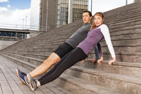 Active young people doing reverse plank exercises Stock Photos