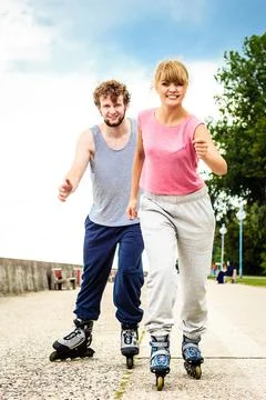 Active young people friends rollerskating outdoor. Stock Photos