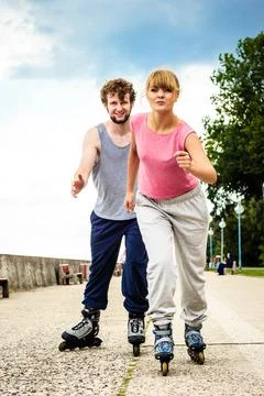 Active young people friends rollerskating outdoor. Stock Photos