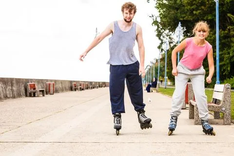 Active young people friends rollerskating outdoor. Stock Photos