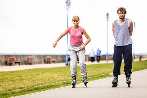 Active young people friends rollerskating outdoor. Stock Photos