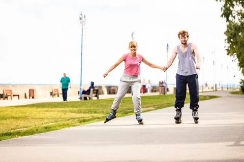 Active young people friends rollerskating outdoor. Stock Photos