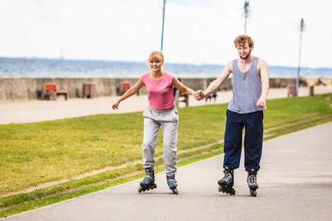 Active young people friends rollerskating outdoor. Stock Photos