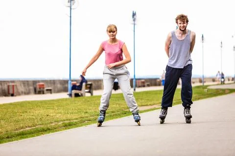 Active young people friends rollerskating outdoor. Stock Photos