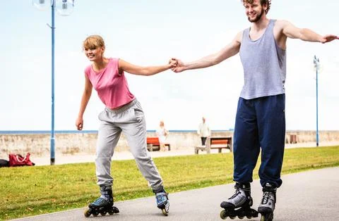 Active young people friends rollerskating outdoor. Stock Photos