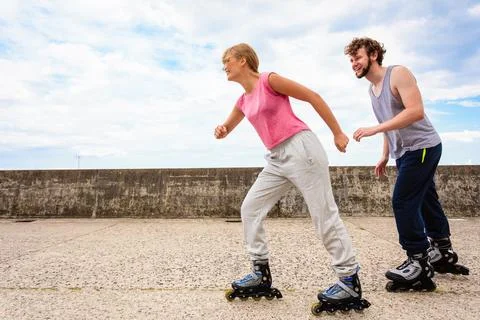 Active young people friends rollerskating outdoor. Stock Photos