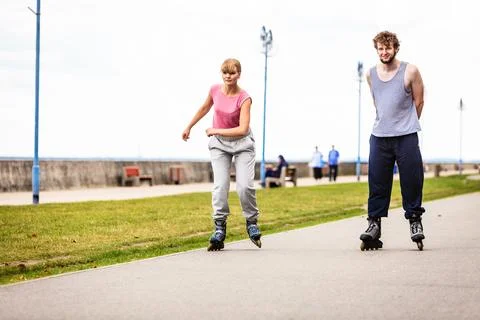 Active young people friends rollerskating outdoor. Stock Photos