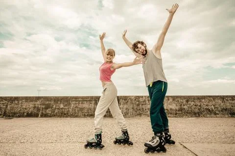 Active young people friends rollerskating outdoor. Stock Photos