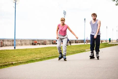 Active young people friends rollerskating outdoor. Stock Photos