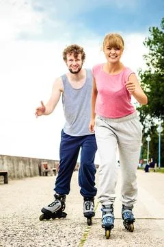 Active young people friends rollerskating outdoor. Stock Photos