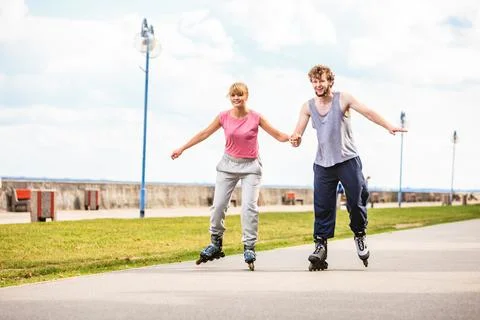 Active young people friends rollerskating outdoor. Stock Photos