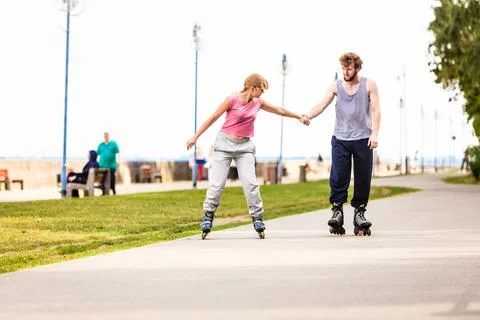 Active young people friends rollerskating outdoor. Stock Photos