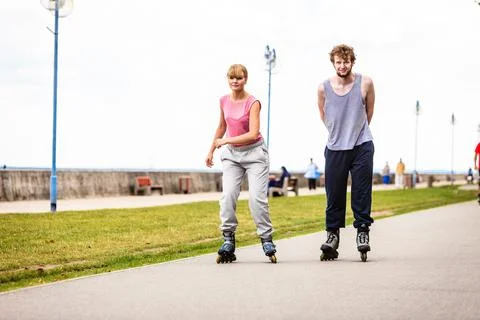 Active young people friends rollerskating outdoor. Stock Photos